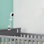 White iTODOS flexible baby monitor mount with an 8-inch arm, clamped to a crib, holding a Nanit Pro baby monitor.