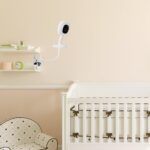 White iTODOS flexible baby monitor mount with an 8-inch arm, clamped to a crib, holding a Nanit Pro baby monitor.