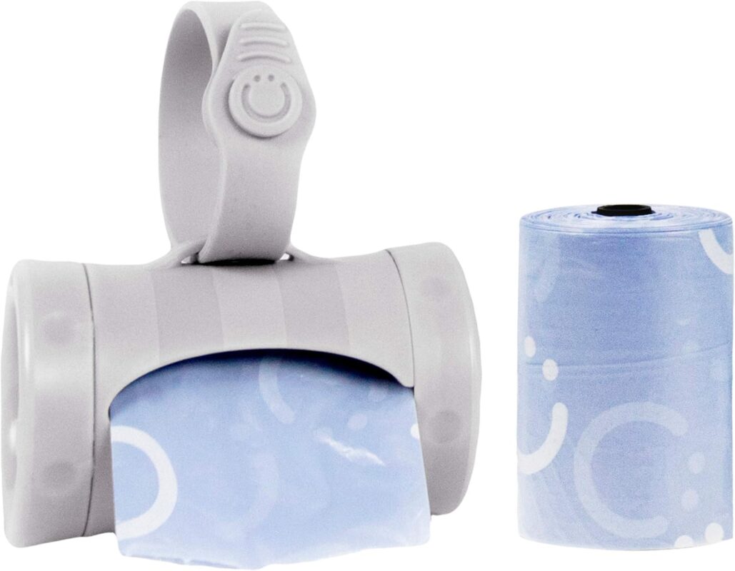 Gray retractable diaper bag dispenser with a roll of lavender-scented bags, clipped to a stroller handle.