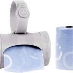 Gray retractable diaper bag dispenser with a roll of lavender-scented bags, clipped to a stroller handle.