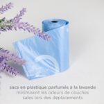Gray retractable diaper bag dispenser with a roll of lavender-scented bags, clipped to a stroller handle.