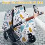 Close-up of a Rquite muslin car seat cover with a dinosaur pattern, draped over an infant car seat.